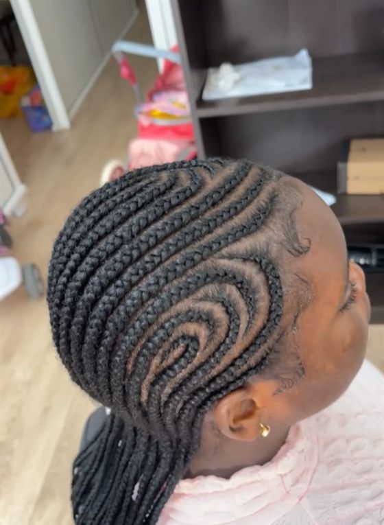 Cornrows con diseño curvo en espiral sobre cabello afro