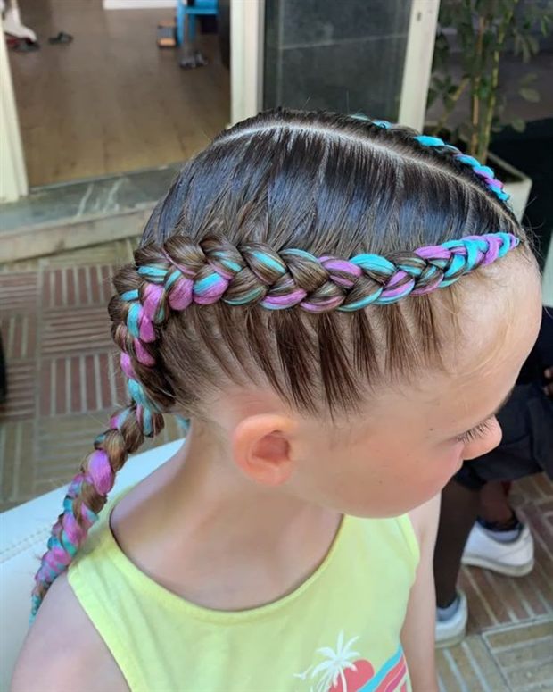 Niña con trenza de raíz y extensiones rosa y turquesa